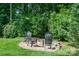 Charming backyard nook features three chairs, rock bed, and lush foliage at 105 Banksridge Rd, Fort Mill, SC 29715