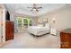 Light-filled main bedroom with tray ceiling, ceiling fan, large window, and neutral decor at 105 Banksridge Rd, Fort Mill, SC 29715