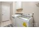 Bright laundry room with modern washer and dryer, overhead cabinets and a tiled floor at 105 Banksridge Rd, Fort Mill, SC 29715