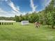 Large backyard with manicured lawn, a shed, play set, and mature trees at 114 Sierra Chase Dr, Statesville, NC 28677