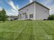 Large backyard featuring lush green grass, home exterior, and an outdoor patio at 114 Sierra Chase Dr, Statesville, NC 28677