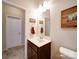 Powder room featuring a vanity with a white sink, dark wood cabinetry, and a decorative wooden mountain art piece at 114 Sierra Chase Dr, Statesville, NC 28677