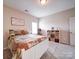 Cozy bedroom with white bed frame, warm colored bedding, and shelves with organized wicker baskets at 114 Sierra Chase Dr, Statesville, NC 28677