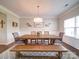 Dining area with seating for six at an elegant wooden table with bench, light fixture, and decorated walls at 114 Sierra Chase Dr, Statesville, NC 28677