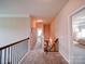Upper hallway featuring neutral carpet, wood railings, and bedroom access at 114 Sierra Chase Dr, Statesville, NC 28677