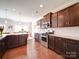 Well-lit kitchen featuring granite countertops, stainless steel appliances, and dark wood cabinets and an eat in area at 114 Sierra Chase Dr, Statesville, NC 28677