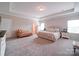 Comfortable primary bedroom featuring a tray ceiling, soft carpet, neutral colors, and large windows for natural light at 114 Sierra Chase Dr, Statesville, NC 28677