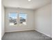 Bright bedroom with neutral carpeting and views of neighborhood through double windows at 116 Obadiah Ct, Mooresville, NC 28115