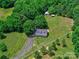 Charming home with a wraparound porch, set amidst mature trees and a fenced yard, exudes curb appeal and country charm at 11850 Sugar Hill Rd, Davidson, NC 28036