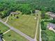 Expansive aerial view of property featuring a large grassy field, multiple residences, and mature trees, all neatly arranged at 11850 Sugar Hill Rd, Davidson, NC 28036