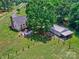 Aerial view of home, sheds, and a large yard with a lush tree at 11850 Sugar Hill Rd, Davidson, NC 28036