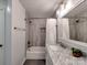 Modern bathroom featuring a shower-tub combo, marble vanity, and tiled walls at 11850 Sugar Hill Rd, Davidson, NC 28036