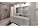 Elegant bathroom with marble-top double vanity, tile accent wall, and a shower-tub combo at 11850 Sugar Hill Rd, Davidson, NC 28036