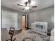 Cozy bedroom with wood floors, ceiling fan, and white baby crib at 11850 Sugar Hill Rd, Davidson, NC 28036