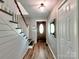 Warm entryway featuring hardwood floors, a wooden staircase, and a decorative front door at 11850 Sugar Hill Rd, Davidson, NC 28036