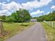 Exterior view of the home at the end of a long, paved driveway at 11850 Sugar Hill Rd, Davidson, NC 28036