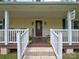 Inviting front porch with beautiful planters flanking a decorative front door and welcome sign at 11850 Sugar Hill Rd, Davidson, NC 28036