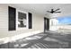 Relaxing covered front porch featuring black shutters and a ceiling fan at 12491 Oak Grove Rd, Stanley, NC 28163