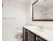 Bathroom with white sink, dark wood cabinet, toilet, mirror, and wainscoting on the wall at 12824 Harvest Time Ct, Charlotte, NC 28278