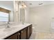 Bathroom with double vanity, granite countertops, dark wood cabinetry, and neutral-toned walls at 12824 Harvest Time Ct, Charlotte, NC 28278