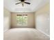 Bedroom featuring neutral carpet, ceiling fan, and dual windows for ample sunlight at 12824 Harvest Time Ct, Charlotte, NC 28278
