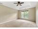 Bedroom featuring neutral carpet, a ceiling fan, and a large window for natural light at 12824 Harvest Time Ct, Charlotte, NC 28278