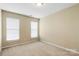 Bedroom has two large windows with white blinds, carpeted flooring and light colored walls at 12824 Harvest Time Ct, Charlotte, NC 28278