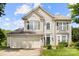 Inviting two-story home features green shutters, a two car garage, and a well-manicured lawn on a sunny day at 12824 Harvest Time Ct, Charlotte, NC 28278