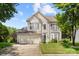 Inviting two-story home features green shutters, a two car garage, and a well-manicured lawn on a sunny day at 12824 Harvest Time Ct, Charlotte, NC 28278