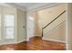 Bright foyer showcasing hardwood floors, a staircase with white railing, and natural light from the window at 12824 Harvest Time Ct, Charlotte, NC 28278