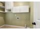 Laundry room with white cabinets and shelving for organized storage at 12824 Harvest Time Ct, Charlotte, NC 28278