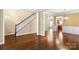 Spacious living room with gleaming hardwood floors, staircase, and a view into adjacent rooms at 12824 Harvest Time Ct, Charlotte, NC 28278