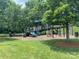 Community playground featuring multiple slides, climbing equipment, and adjacent green space at 12824 Harvest Time Ct, Charlotte, NC 28278