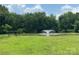 Community pond with fountain, bench, and surrounding trees at 12824 Harvest Time Ct, Charlotte, NC 28278