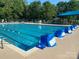 Community swimming pool with multiple lap lanes, poolside chairs, and shaded tables for residents at 12824 Harvest Time Ct, Charlotte, NC 28278