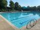 Community swimming pool with multiple lap lanes, poolside chairs, and shaded tables for residents at 12824 Harvest Time Ct, Charlotte, NC 28278
