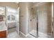Bathroom featuring a glass-enclosed shower with tile surround and a door that leads to the bedroom at 13107 Heath Grove Dr, Huntersville, NC 28078