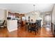 Open kitchen with wooden cabinets, stainless steel appliances, and adjacent dining area with hardwood floors at 13107 Heath Grove Dr, Huntersville, NC 28078