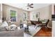 Bright living room featuring hardwood floors, a comfortable seating arrangement, and a decorative ceiling fan at 13107 Heath Grove Dr, Huntersville, NC 28078