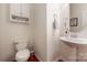 Neat powder room featuring a pedestal sink, modern fixtures, and a wall-mounted cabinet for storage at 13107 Heath Grove Dr, Huntersville, NC 28078