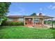 Charming brick home featuring a cozy front porch and a well-manicured lawn with mature landscaping at 1609 Troy Rd, Shelby, NC 28150
