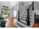 Bright foyer with hardwood floors, an open staircase with dark railings, and a view of the front door at 161 Dairy Farm Rd, Mooresville, NC 28115