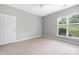 Neutral bedroom with a window offering views of the grounds and white trim at 17111 Doe Valley Ct, Cornelius, NC 28031