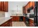 Modern kitchen with dark wood cabinets, stainless steel appliances, and quartz countertops at 17111 Doe Valley Ct, Cornelius, NC 28031