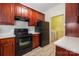 Modern kitchen with dark wood cabinets, stainless steel appliances, quartz countertops, and adjacent laundry room at 17111 Doe Valley Ct, Cornelius, NC 28031