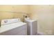 Bright laundry room equipped with a washer, dryer, and shelving at 17111 Doe Valley Ct, Cornelius, NC 28031