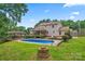 Expansive backyard features a pool, spacious grassy yard, and an outdoor deck at 1724 Windy Rush Ln, Gastonia, NC 28054