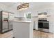 Bright kitchen featuring white cabinets, stainless steel appliances, and a center island at 1724 Windy Rush Ln, Gastonia, NC 28054
