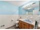 Bathroom featuring blue walls, tiled wainscoting, wood vanity, and blue sink at 1822 N New Hope Rd, Gastonia, NC 28054