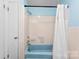 Bathroom showcasing a blue tub, tiled walls, and a white shower curtain at 1822 N New Hope Rd, Gastonia, NC 28054